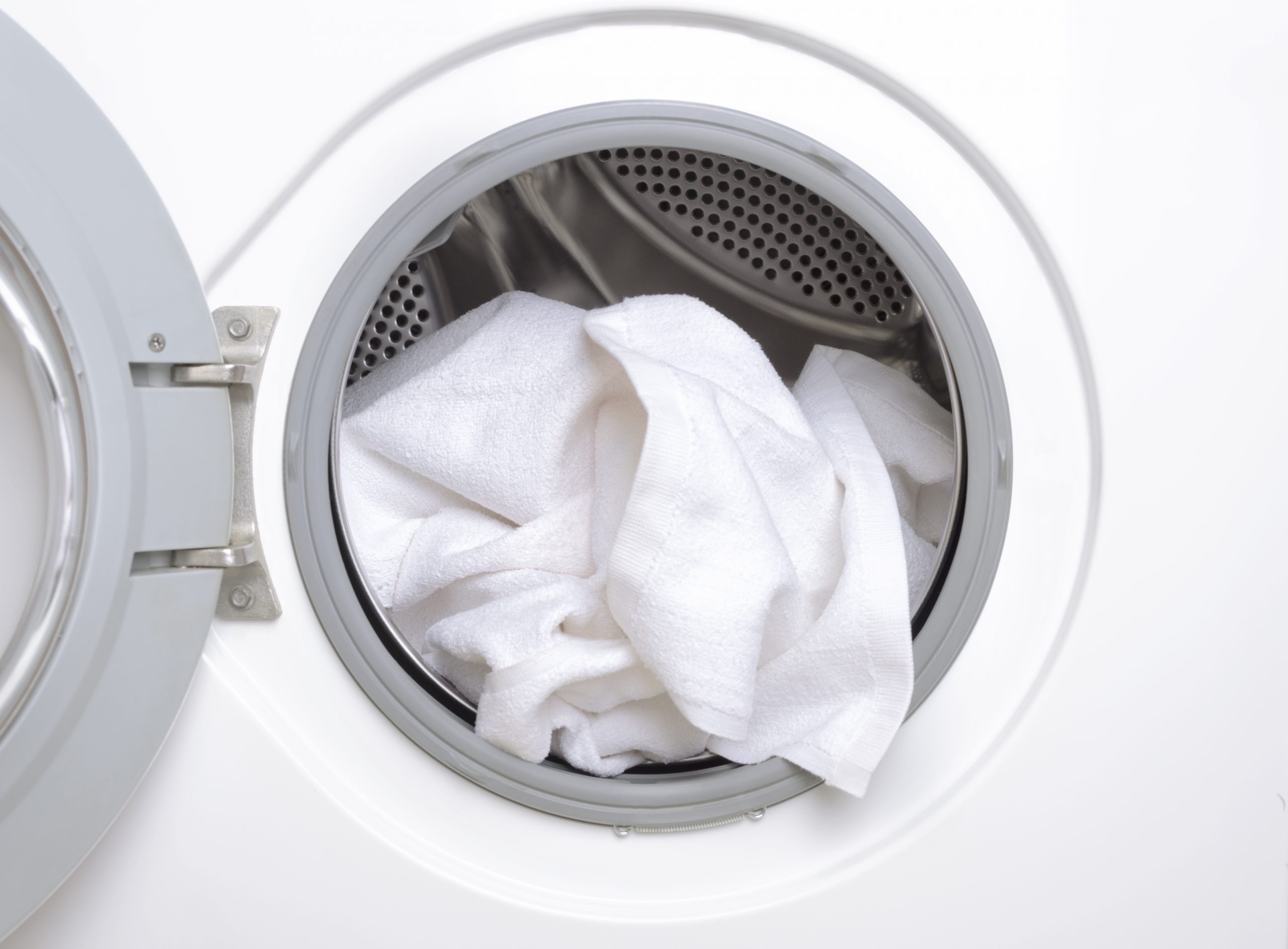 Finishing a part house, washing the white towels.Closeup of washing machine drum