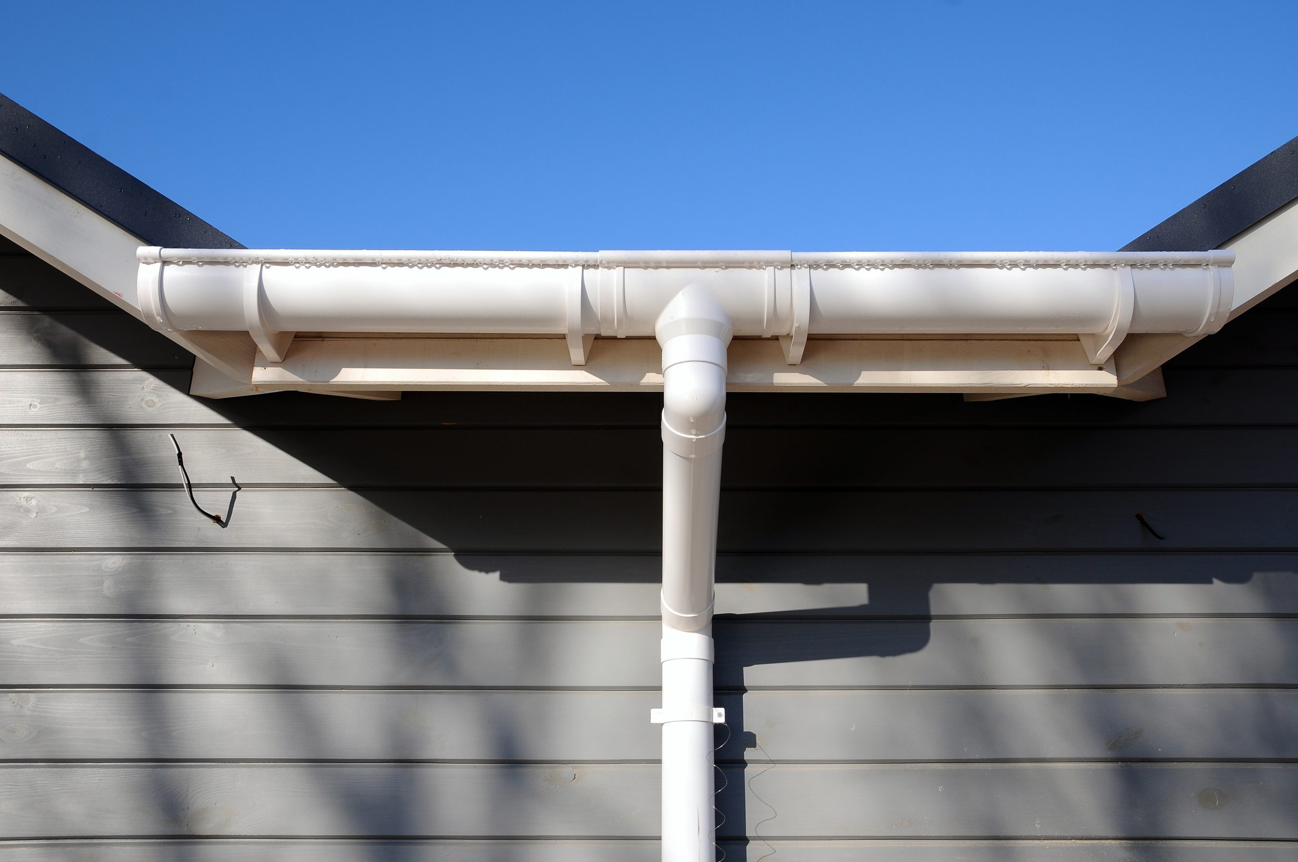 New rain gutter on a home against blue sky.