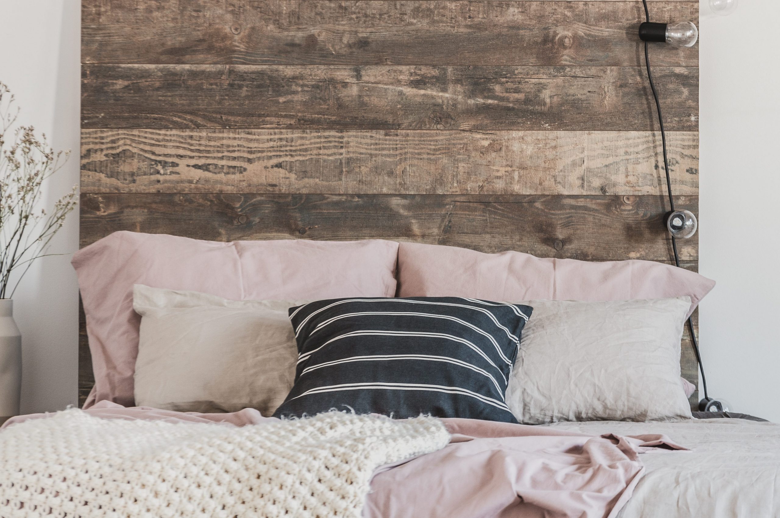 Cute ducks on grey oil painting in white rustic bedroom interior with fancy bookshelf and bed with wooden headboard